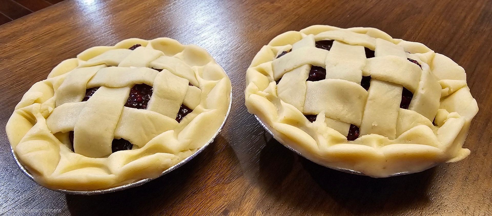 Two mini berry pies with hand-woven lattice crusts