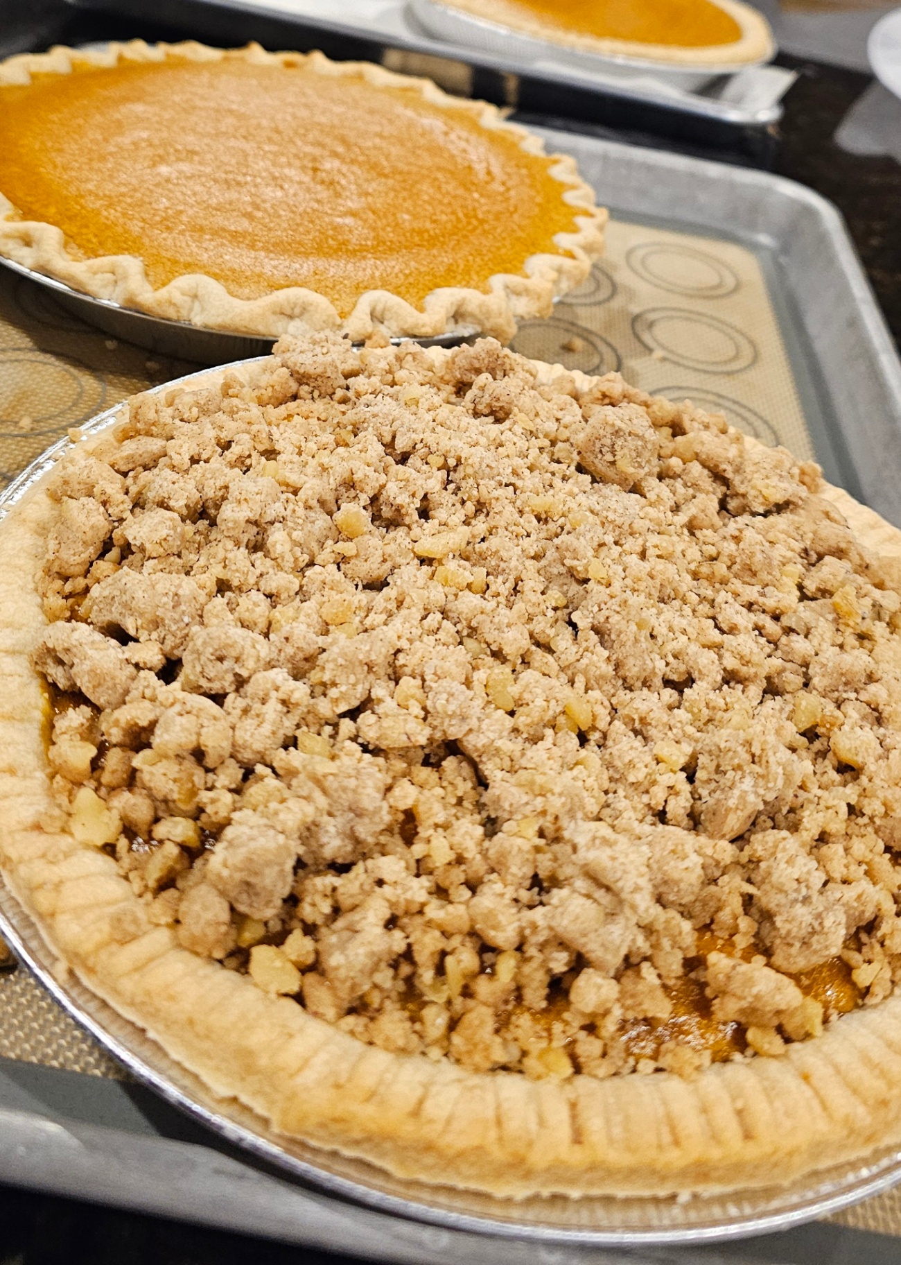 Pumpkin pie next to an apple streusel crumb pie