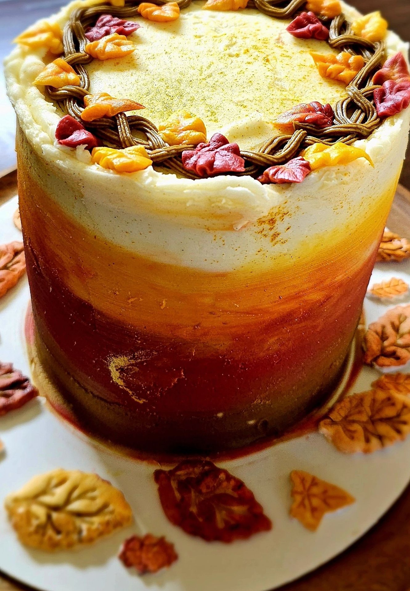 Autumn ombré cake with piped fall-leaf wreath in red, orange, and gold