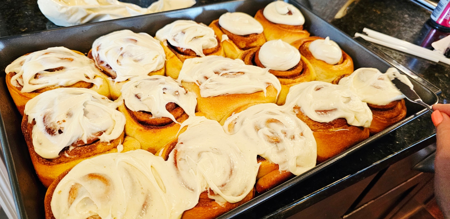 Pan of freshly frosted cinnamon rolls with cream cheese icing