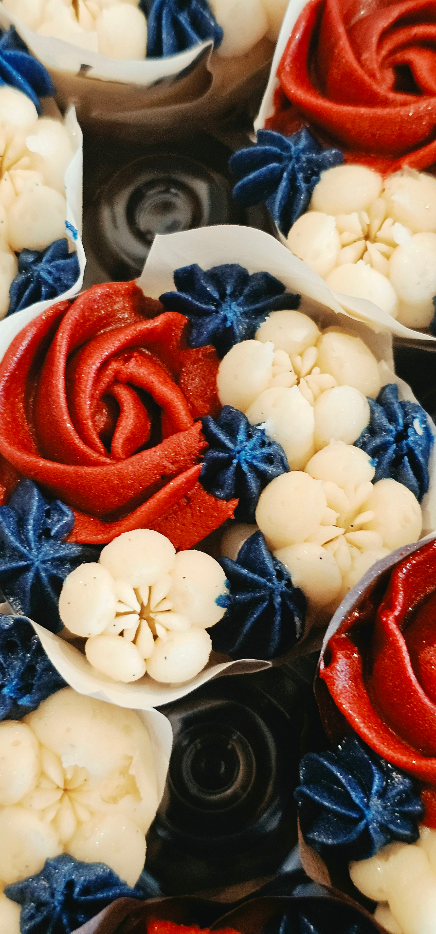Patriotic red, white, and blue buttercream cupcakes with roses and stars