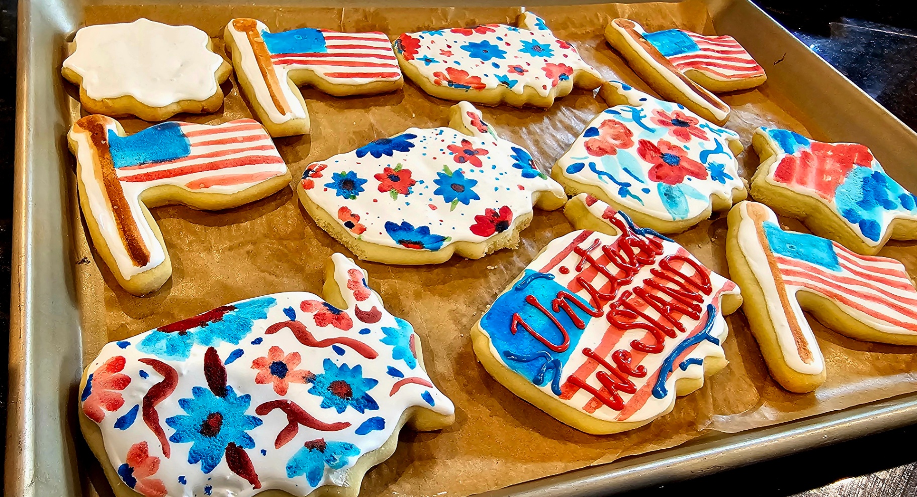 Patriotic cookies with hand-painted American flags, florals, and 'United We Stand'