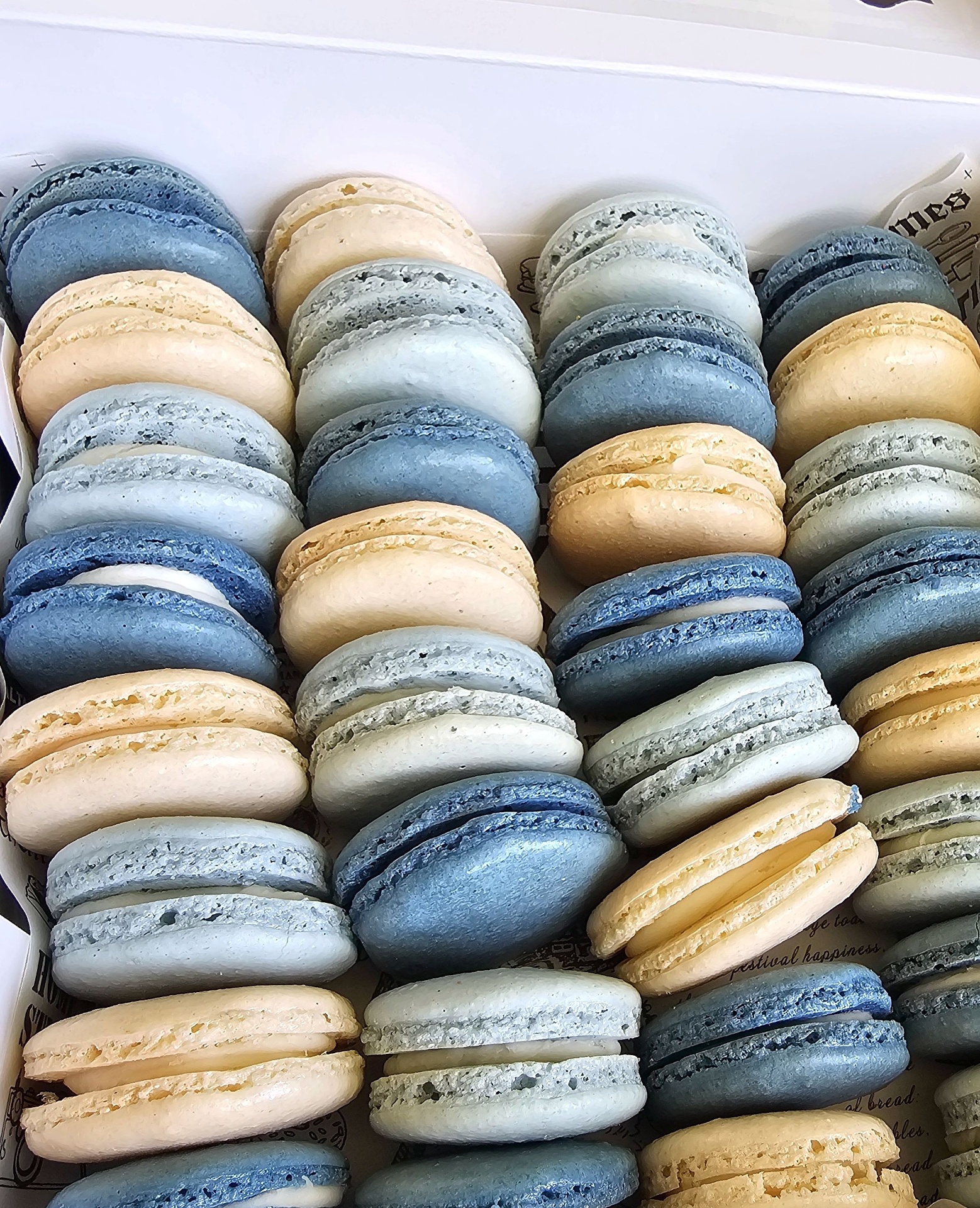 Assorted macarons in blue, cream, and grey